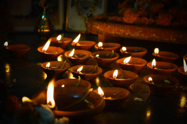 Traditional earthen lamps arranged in a beautiful pattern with colored rangoli (powder) designs on the occasion of Diwali festival
